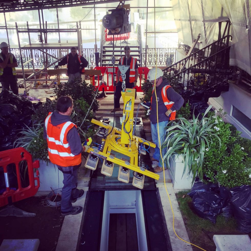 machinery being used to move in glass floor panel
